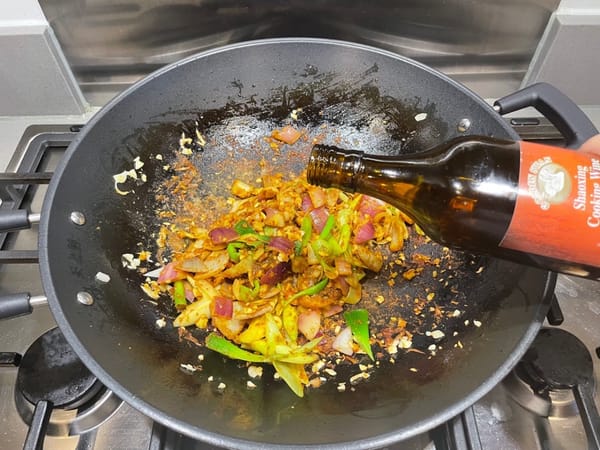 Ajoutez du vin de cuisson sur le côté du wok pour rehausser l’arôme.