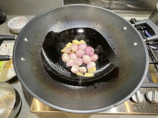 Heat oil in a wok and sauté shallots over medium-low heat.