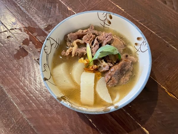 Tambahkan daging sandung lamur dan kaldu lobak, lalu tambahkan topping sesuai selera: daun bawang cincang, daun kemangi, dan bawang kering.