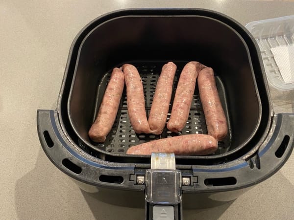 Coloque las salchichas frescas en la freidora de aire, asegurándose de que no se toquen entre sí. Es importante no sobrecargar la canasta para que se cocinen de manera uniforme.