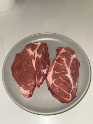 用鹽和黑胡椒輕輕調味豬肩肉的兩面