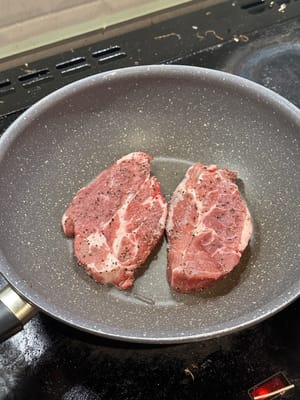 在一口薄薄的油鍋中，將豬肩肉煎至略為焦黃