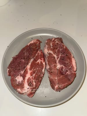 Lightly season both sides of the pork shoulder with salt and black pepper