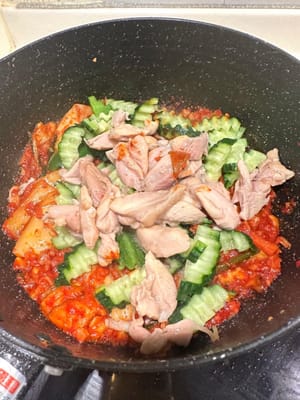 鶏肉とキュウリを加えて炒め続ける