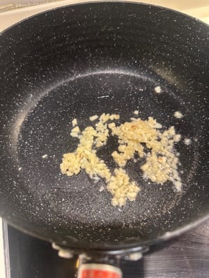 同じフライパンに油を追加し、みじん切りにしたニンニクを香りが立つまで炒めます。
