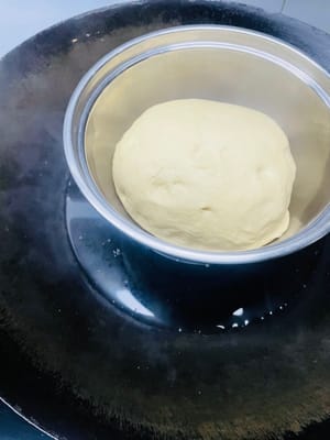 Coloca la masa en un lugar a unos 30 °C para que fermente. ¡Recuerda cubrirla con film transparente para mantenerla húmeda! Si hace frío, ponla en el horno o en una olla con un recipiente con agua caliente debajo para que fermente hasta que doble su volumen.