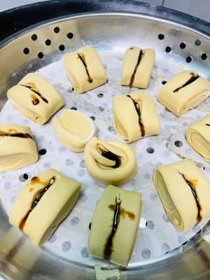 Unte con aceite la rejilla de la vaporera o cúbrala con papel antiadherente, coloque las piezas de masa cortadas sobre ella, vierta agua caliente a unos 60 °C en la olla y deje reposar la masa durante 20 minutos. Antes de que suba, haga un corte en el centro de la masa, exprima un poco de jarabe de azúcar moreno líquido, espolvoree con nueces tostadas picadas y espere a que la masa haya subido 1,5 veces su volumen original antes de cocinarla al vapor durante 13 minutos. Después de apagar el fuego, deje reposar 5 minutos.