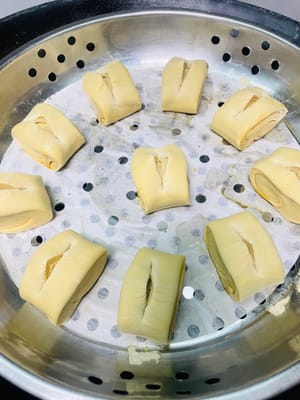 Unte con aceite la rejilla de la vaporera o cúbrala con papel antiadherente, coloque las piezas de masa cortadas sobre ella, vierta agua caliente a unos 60 °C en la olla y deje reposar la masa durante 20 minutos. Antes de que suba, haga un corte en el centro de la masa, exprima un poco de jarabe de azúcar moreno líquido, espolvoree con nueces tostadas picadas y espere a que la masa haya subido 1,5 veces su volumen original antes de cocinarla al vapor durante 13 minutos. Después de apagar el fuego, deje reposar 5 minutos.