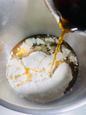 Agregue 5 g de manteca de cerdo, 250 g de harina, 3 g de levadura y 2 g de sal al agua con azúcar morena enfriada, vierta todo en el tazón y amáselo hasta obtener una masa suave.