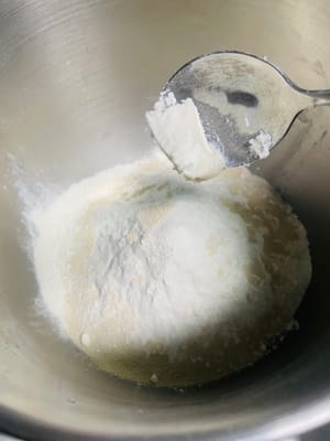 Agregue 5 g de manteca de cerdo, 250 g de harina, 3 g de levadura y 2 g de sal al agua con azúcar morena enfriada, vierta todo en el tazón y amáselo hasta obtener una masa suave.