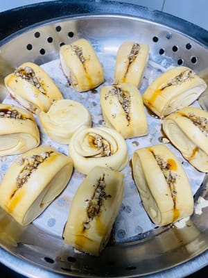 Unte con aceite la rejilla de la vaporera o cúbrala con papel antiadherente, coloque las piezas de masa cortadas sobre ella, vierta agua caliente a unos 60 °C en la olla y deje reposar la masa durante 20 minutos. Antes de que suba, haga un corte en el centro de la masa, exprima un poco de jarabe de azúcar moreno líquido, espolvoree con nueces tostadas picadas y espere a que la masa haya subido 1,5 veces su volumen original antes de cocinarla al vapor durante 13 minutos. Después de apagar el fuego, deje reposar 5 minutos.