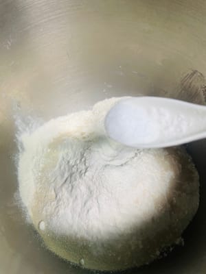 Agregue 5 g de manteca de cerdo, 250 g de harina, 3 g de levadura y 2 g de sal al agua con azúcar morena enfriada, vierta todo en el tazón y amáselo hasta obtener una masa suave.