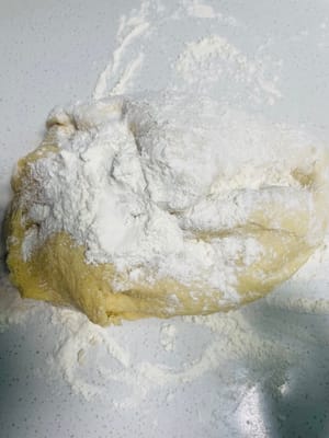 Espolvorea harina seca sobre la superficie de trabajo, retira la masa levada, añade un poco más de harina y amásala hasta que puedas abrirla con un cuchillo y no veas ningún agujero de aire visible en los lados. ¡Este paso es clave para una superficie lisa para los bollos al vapor!