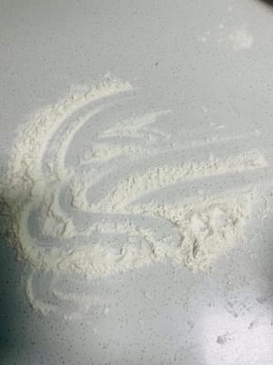 Espolvorea harina seca sobre la superficie de trabajo, retira la masa levada, añade un poco más de harina y amásala hasta que puedas abrirla con un cuchillo y no veas ningún agujero de aire visible en los lados. ¡Este paso es clave para una superficie lisa para los bollos al vapor!