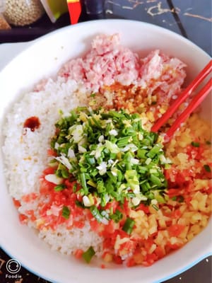 在一個大攪拌碗中，加入豬肉末、瀝乾水分的糯米和切丁的蔬菜。