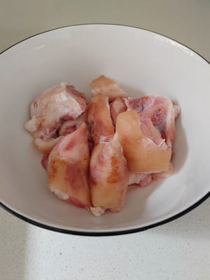 Lavare gli zampetti di maiale e tagliarli a pezzetti.