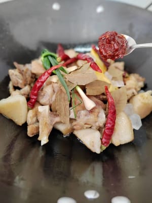 Soffriggere fino a leggera doratura, quindi aggiungere lo zenzero, la cipolla e l'aglio preparati. Salsa di soia chiara, salsa di soia scura, pasta di fagioli, salsa di ostriche, foglie di alloro, peperoncini secchi e zucchero di canna.