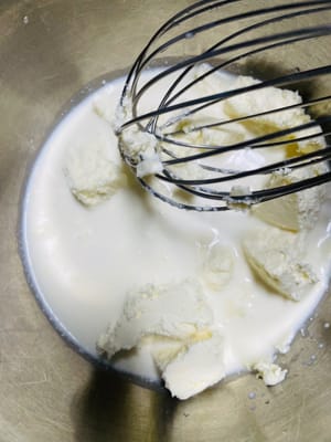 200 g Frischkäse bei Zimmertemperatur weich werden lassen, 100 g Milch hinzufügen und in heißem Wasser schmelzen. Mit einem Schneebesen schlagen, bis die Masse glatt und frei von Partikeln ist.
