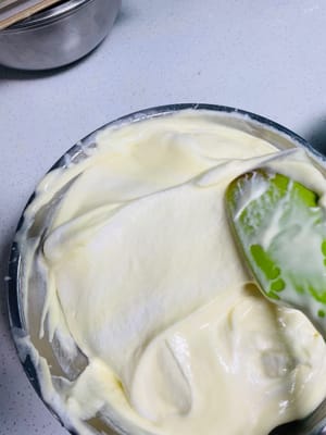 Versare tutta la pasta di tuorli d'uovo mescolata nella meringa rimanente e mescolare nuovamente con un movimento a forma di N per ottenere un impasto liscio per cheesecake.