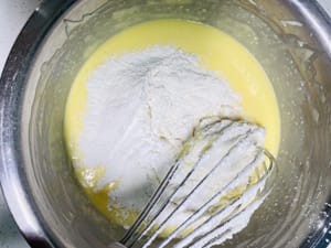 Eigelb glatt rühren. Anschließend das zuvor vermischte Kuchenmehl und die Maisstärke zur Eigelbmasse geben und gleichmäßig in N-förmigen Bewegungen unterheben. (Hinweis: Diese Bewegung muss unbedingt nach der Mehlzugabe wiederholt werden, um Glutenbildung im Teig zu vermeiden.)

Im Video erfahren Sie mehr über die richtigen Falttechniken.