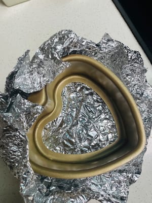 Bereiten Sie die Kuchenform (bei einer Form mit herausnehmbarem Boden den Boden fest mit Alufolie umwickeln, damit beim Backen im Wasserbad kein Wasser eindringt) und das Backblech vor. Da wir dieses Mal die Wasserbadmethode verwenden, müssen Sie im Voraus einen Behälter für Wasser vorbereiten und diesen zusammen mit dem Kuchen in den Ofen stellen.