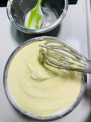 Die gesamte angerührte Eigelbpaste in die restliche Baisermasse geben und nochmals in einer N-förmigen Faltbewegung unterheben, bis ein geschmeidiger Käsekuchenteig entsteht.