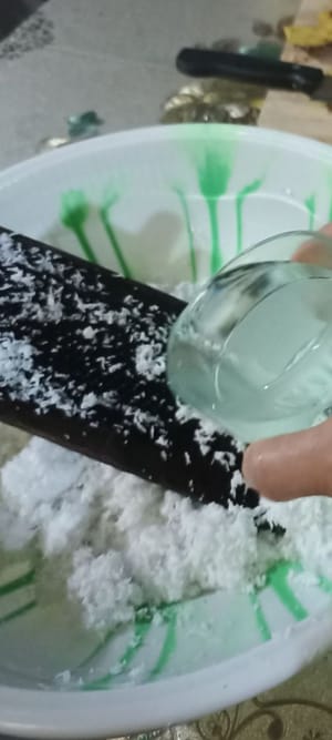 aggiungere 400 ml di acqua tiepida a un contenitore contenente cocco grattugiato per preparare il latte di cocco.