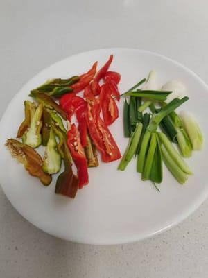 Cortar el pimiento y picar la cebolla verde en trozos pequeños.