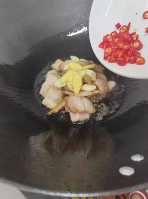 Agregue jengibre, ajo, chile picante y una cucharadita de salsa de soja oscura y saltee hasta que esté fragante.
