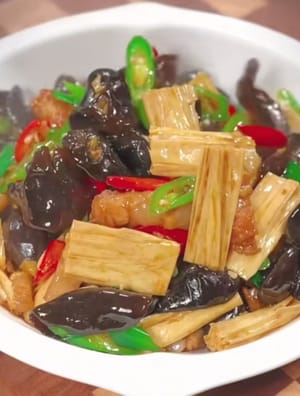 Un plato colorido de tofu frito con hongo negro está listo