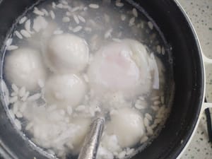 When the glutinous rice balls are almost done, add two eggs and cook for 40 seconds. Turn off the heat when the egg yolks are a little soft and set aside.