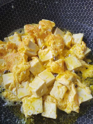 Poner 20 gramos de aceite en una sartén. Verter la mezcla de tofu y huevo, freír el tofu a fuego lento hasta que esté dorado por todos lados y reservar.