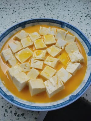 Vierta el líquido del huevo preparado en el tofu.