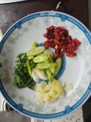 Cortar los brotes de ajo en trozos pequeños y picar el ajo en trozos pequeños.