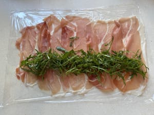 Lalu masukkan daun arugula yang sudah dicuci bersih di bagian bawah, sisakan sedikit celah untuk menggulung