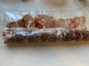 Gulung prosciutto dengan rapat dan potong menjadi ukuran gigitan