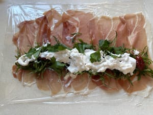 Tiriskan burrata, sobek dan ratakan pada roti gulung