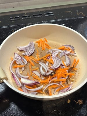 在热锅中，用芝麻油煎洋葱和胡萝卜约 3 分钟/变软