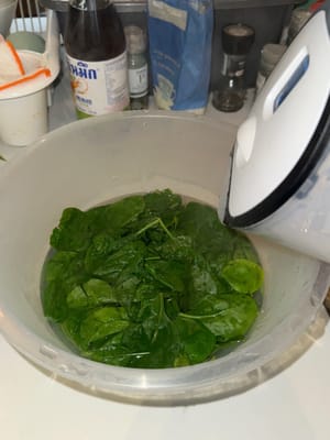 取一个大碗，将沸水倒入菠菜中，浸泡 2 分钟，然后滤干