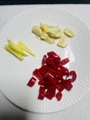 接著準備配菜:蒜給它切成片,薑切成細細的絲,辣椒剁成小顆粒,都給它收拾好擱旁邊待命。