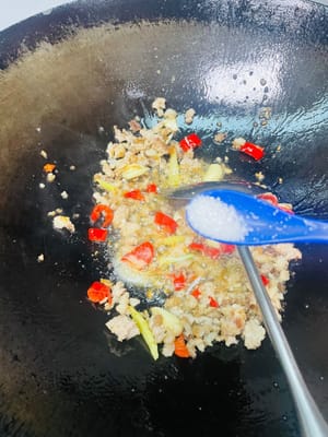 這時候把炒好的肉沫推到鍋邊,把薑蒜和辣椒倒進去炒香,香到你想拿勺子抿一口那味兒就對了,然後再跟肉沫混到一塊兒翻勻。