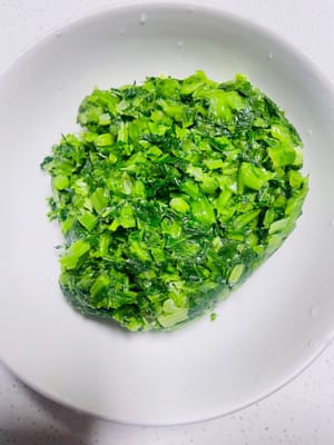 等雪裡紅徹底涼透了,你就上手把它的水使勁擠乾——能擠多乾就多幹,別心疼哈。再切成碎末末,盡量切得碎一點,跟剁餃子餡似的才入味。要是家裡有濾渣袋,那就再把這碎雪裡紅裝進去擠一遍水,這麼操作完,等下炒出嚟才不會濕噠噠的。