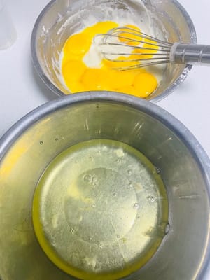 Pisahkan putih telur dan kuning telur: pisahkan putih telur dan kuning telur, masukkan kuning telur ke dalam mangkuk adonan, dan taruh putih telur di mangkuk bersih lainnya. Hati-hati jangan sampai kuning telur tercampur dengan putih telur, dan mangkuk putih telur harus benar-benar bebas dari air dan minyak, jika tidak putih telur tidak bisa dikocok.