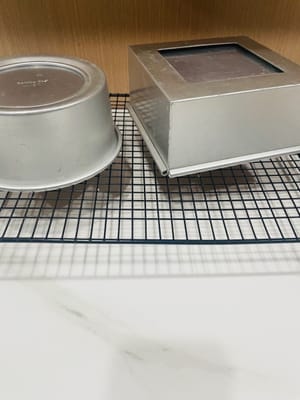 Balikkan loyang agar dingin: Segera setelah dikeluarkan dari oven, jatuhkan cetakan dengan perlahan untuk menghilangkan panas dan mencegah bagian atas menyusut. Kemudian balikkan loyang agar dingin hingga benar-benar matang (sekitar 1 jam).