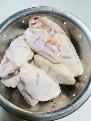 給雞翅「松肉入味」:
把雞中翅中間切兩刀,加生粉和少許鹽,像搓衣服一樣抓洗1分鐘,把雞翅表面的油脂和雜質洗乾淨,瀝乾水備用。這一步是雞翅入味又不腥的關鍵!