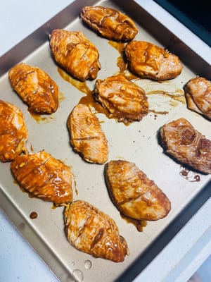 焗爐「伺候」雞翅:
提前預熱焗爐到180°C,把雞翅鋪在焗盤上(別疊著放)。送進焗爐先烤15分鐘,然後拿出嚟翻個面,再烤13分鐘,烤到雞翅表面金黃焦香就成。