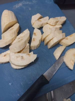 En attendant que la pâte refroidisse, on épluche les bananes et on les coupe en morceaux.