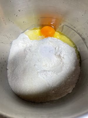 把高筋面粉、酵母、盐、白糖倒进厨师机搅拌盆,再加入椰浆、纯牛奶(天气热用冰牛奶)、淡奶油、鸡蛋液加入和面桶。