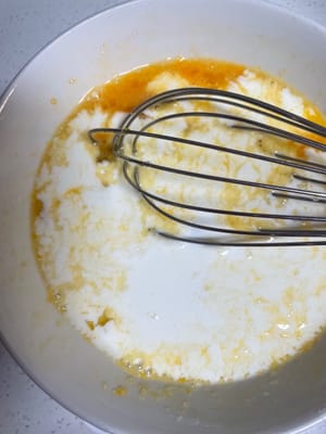 趁发酵的时候做椰蓉馅(好吃的灵魂)
鸡蛋、牛奶、白糖倒一起搅打均匀,再加入低筋面粉翻拌到没有干粉,有点小面疙瘩也不怕,等下炒的时候会压碎。