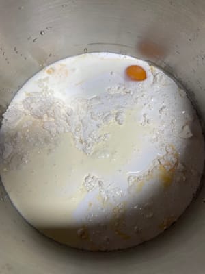 把高筋面粉、酵母、盐、白糖倒进厨师机搅拌盆,再加入椰浆、纯牛奶(天气热用冰牛奶)、淡奶油、鸡蛋液加入和面桶。